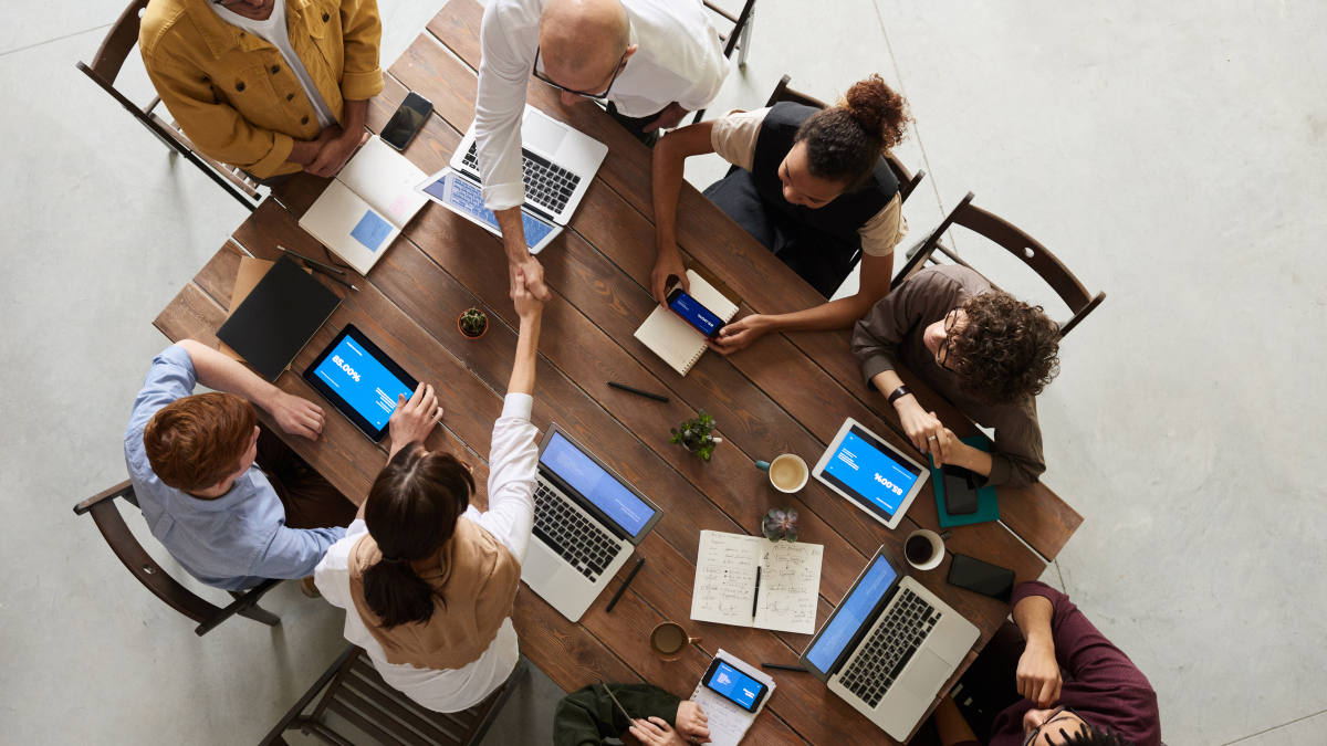 Pessoas colaborando com notebooks e tablets em um ambiente educacional